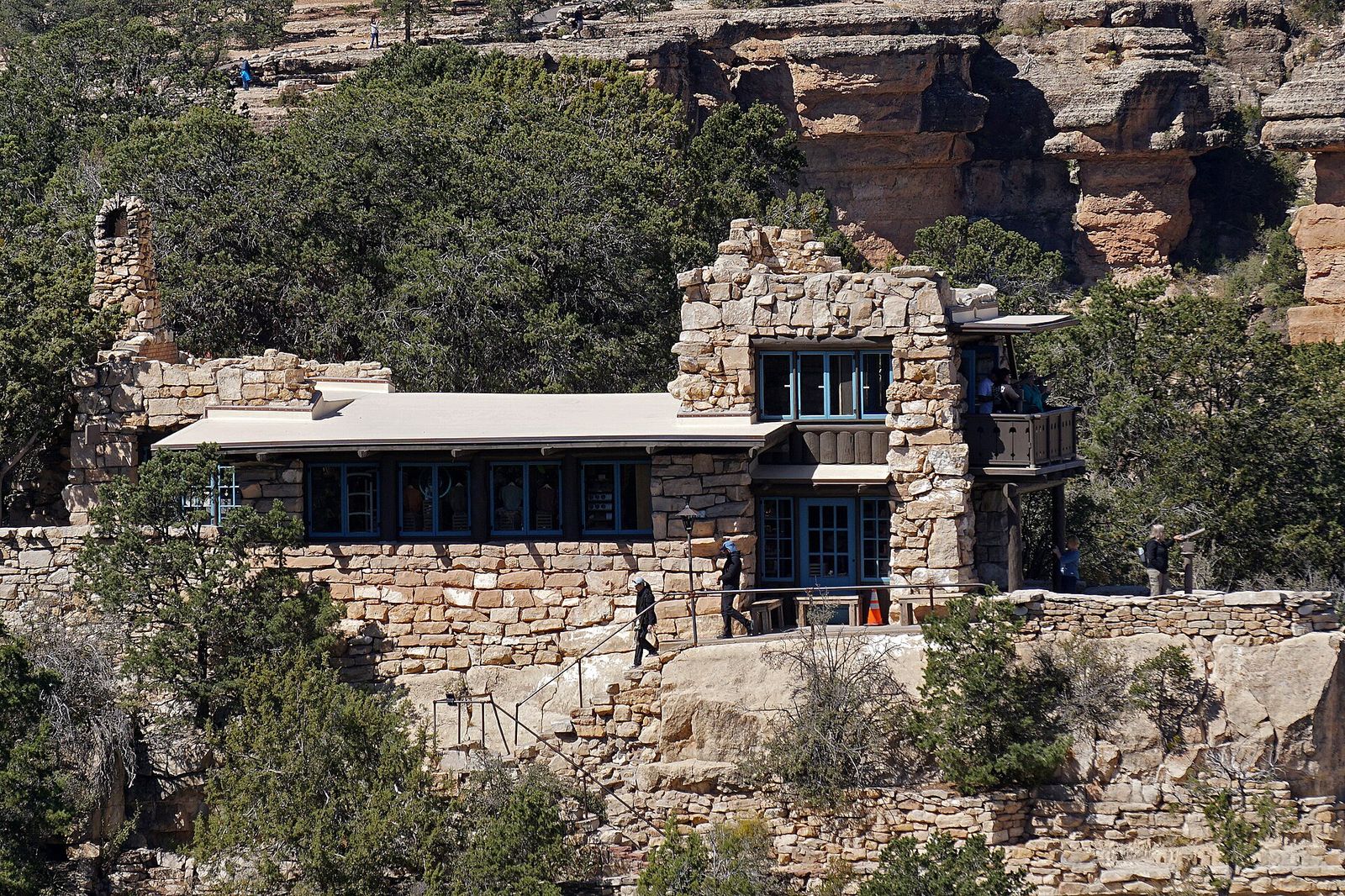 Historic Lookout Studio perched on the South Rim at Grand Canyon Village with visitors exploring outside.