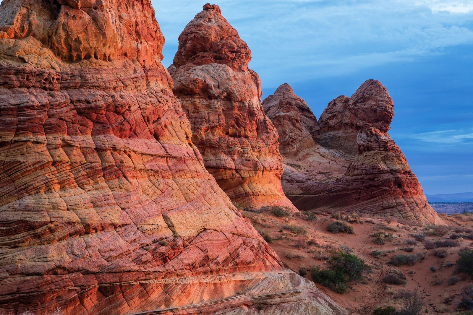 Towering sandstone teepee formations glow orange and red at Paria Canyon-Vermilion Cliffs in northern Arizona.