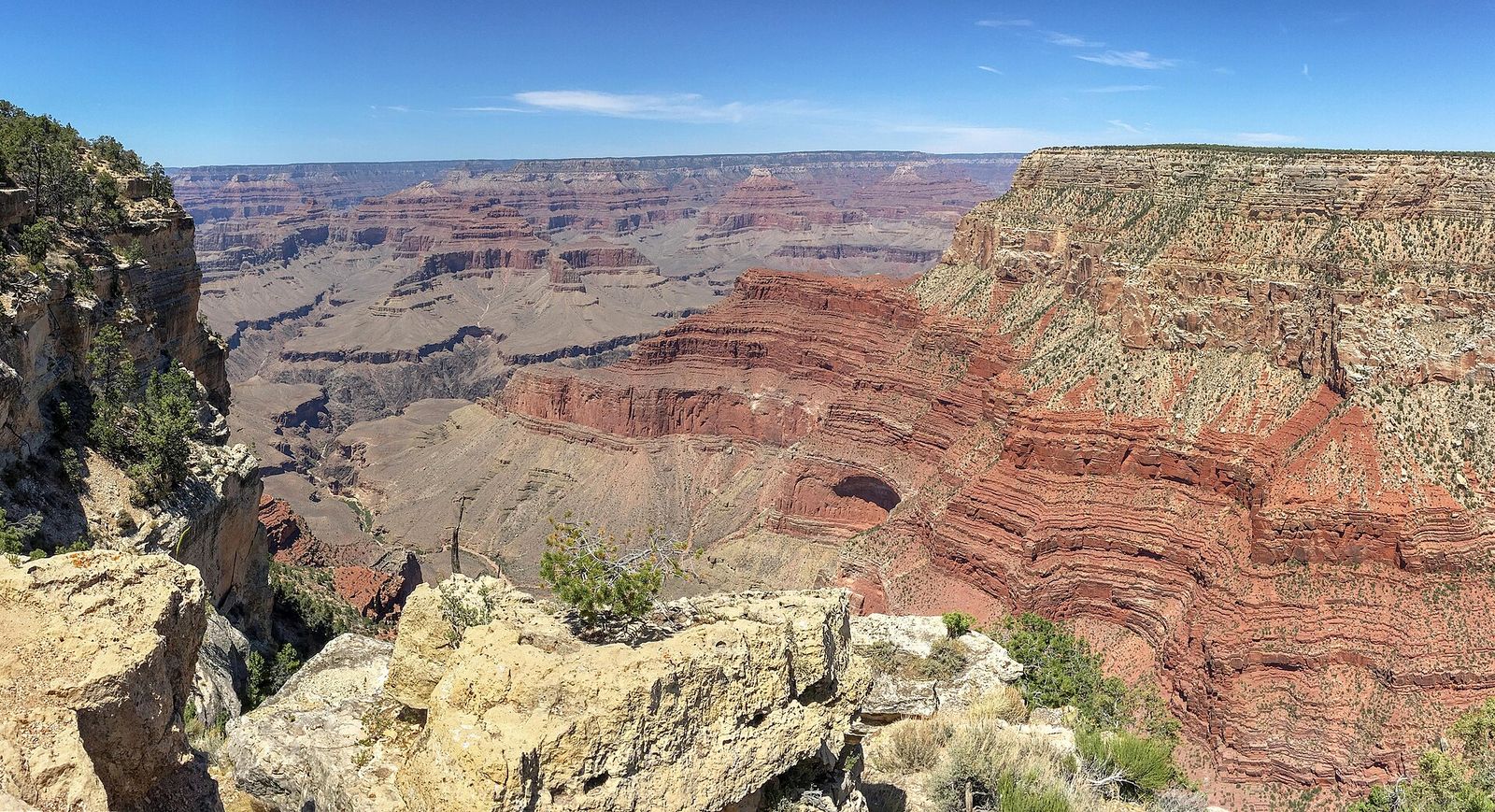 Monument Creek Vista, Grand Canyon South Rim A sweeping panoramic view of Grand Canyon's layered red rock formations under a clear blue sky.