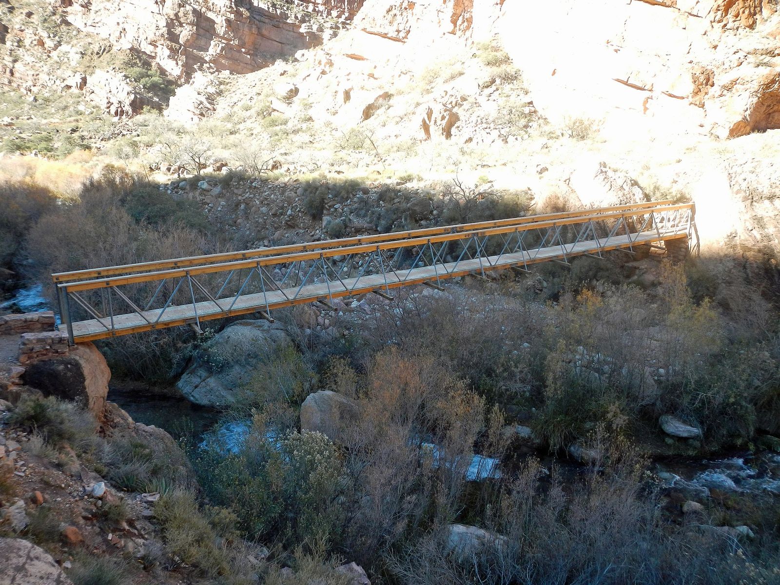 Ribbon Falls Trail Bridge Over Bright Angel Creek A metal footbridge spans Bright Angel Creek along the Ribbon Falls Trail deep inside the Grand Canyon.