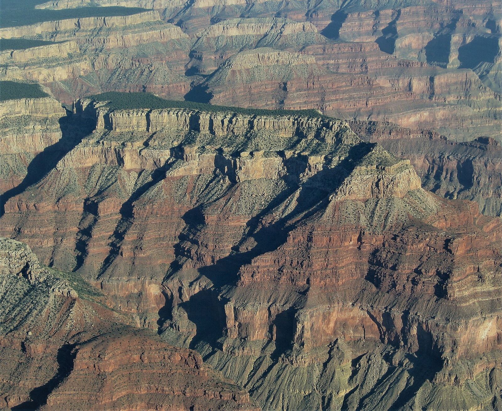 Aerial view of Diana Temple butte rising above deeply layered red rock canyon walls at Grand Canyon's South Rim.