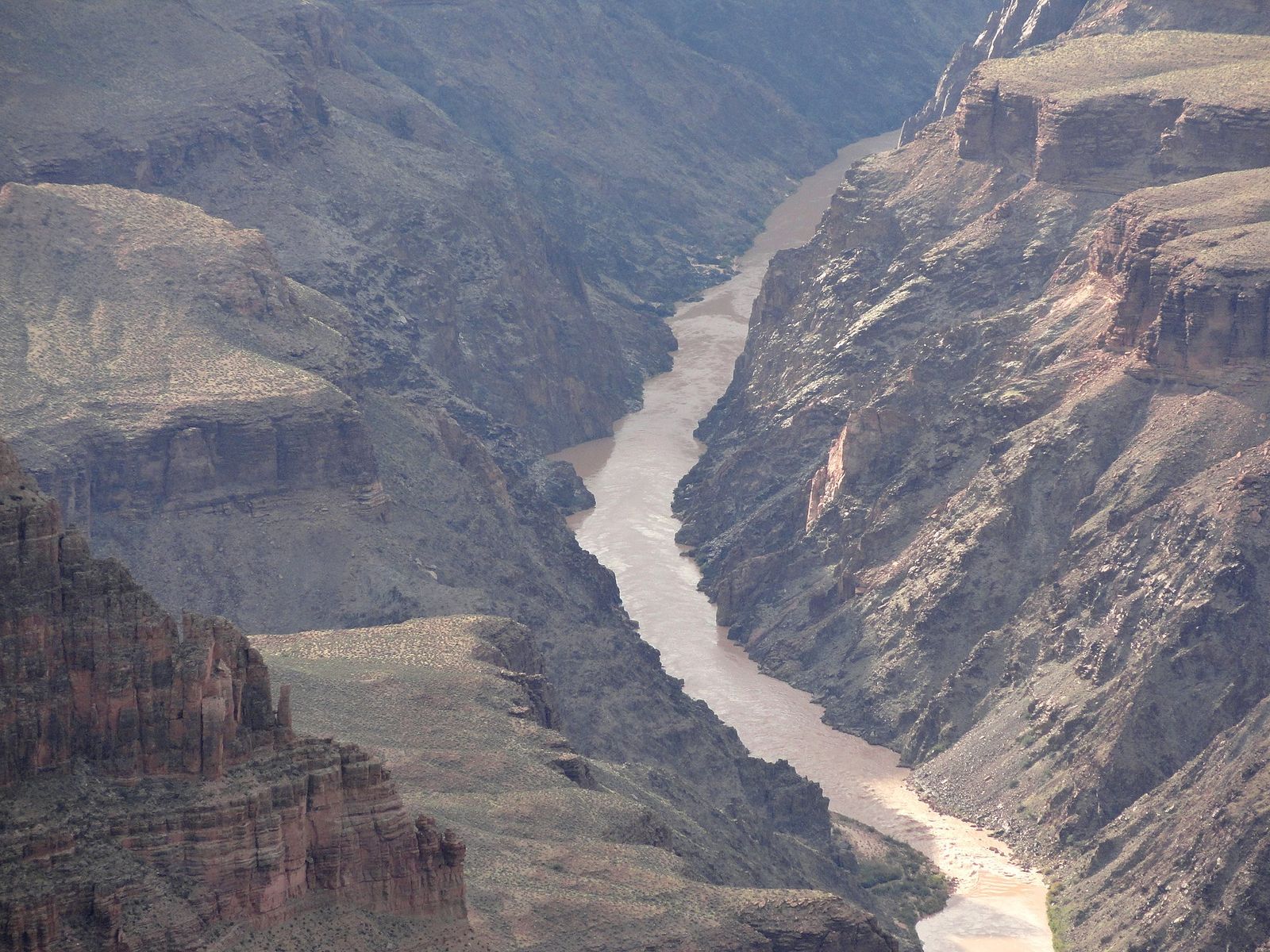 The muddy Colorado River winds through the steep inner gorge of Grand Canyon National Park.