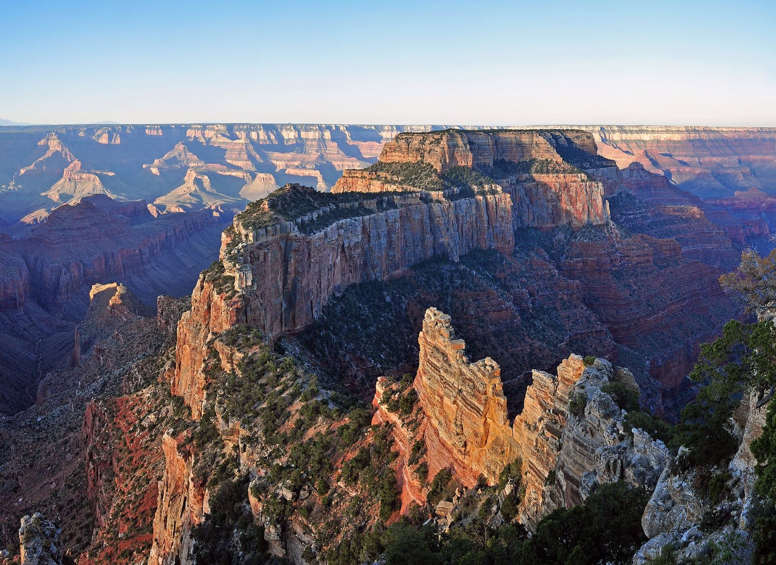 Layered red rock buttes and canyon walls glow in soft morning light at Cape Royal on the North Rim.