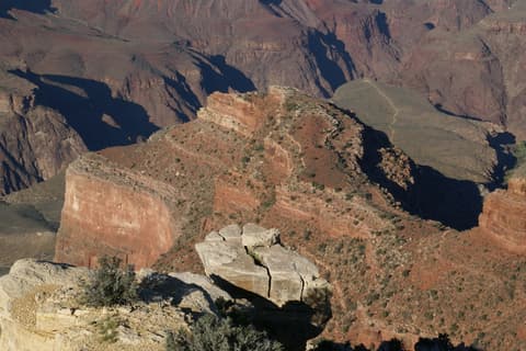 A cracked limestone slab in the foreground frames layered red rock buttes deep inside Grand Canyon National Park.