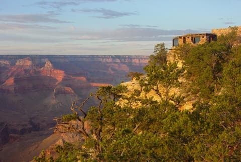Yavapai Point Geology Museum perched on the South Rim overlooking the vast Grand Canyon at golden hour.