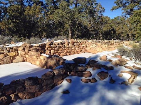 Snow-dusted ancient Pueblo stone ruins at Tusayan Ruin on the Grand Canyon South Rim in winter.