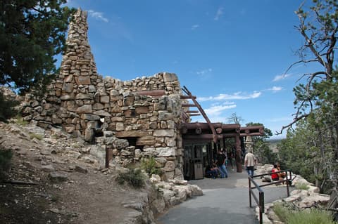 Visitors walk past the iconic rustic stone facade of Hermit's Rest on Grand Canyon's South Rim.