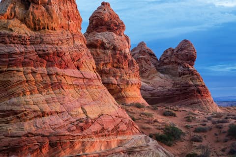 Towering sandstone teepee formations glow orange and red at Paria Canyon-Vermilion Cliffs in northern Arizona.