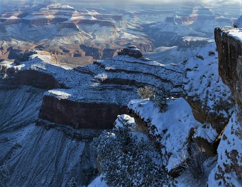 Snow blankets O'Neill Butte and layered canyon walls at Grand Canyon National Park in winter.
