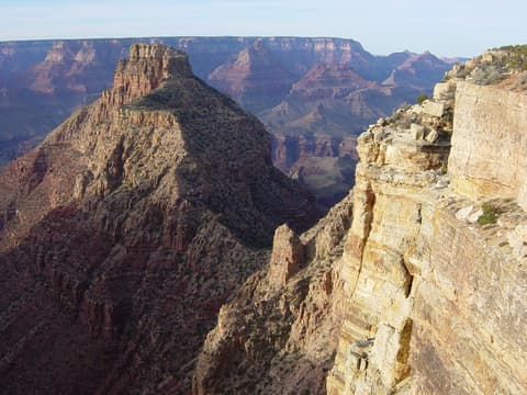 A dramatic Grand Canyon view from the South Rim showing Coronado Butte rising above layered canyon walls and deep shadows.