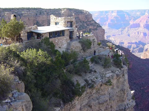 Historic Lookout Studio perched on the South Rim cliff edge overlooking the vast Grand Canyon layers below.