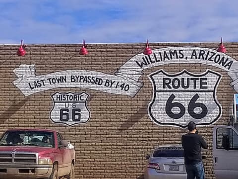 A bold Route 66 mural on a brick wall in Williams, Arizona, the last town bypassed by I-40.