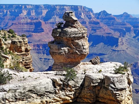 Duck on a Rock hoodoo formation on the South Rim with Grand Canyon's layered cliffs stretching behind it.