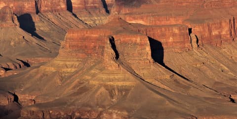 Dramatic aerial view of Howlands Butte rising from the Grand Canyon's layered red sandstone inner canyon.