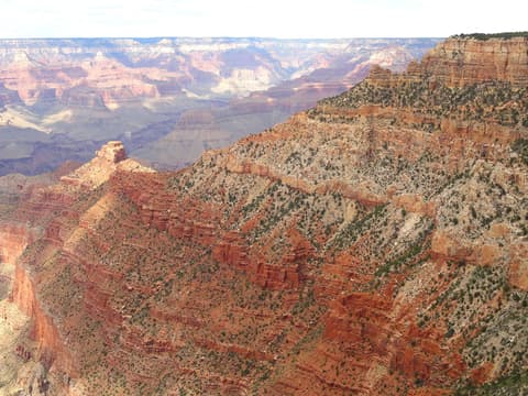 Sweeping panoramic view of layered red rock formations and canyon depths at Pipe Creek Vista, Grand Canyon National Park.