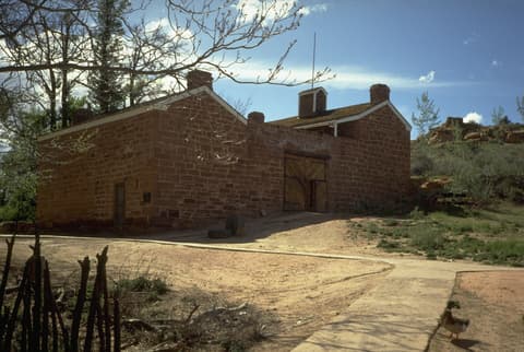 Historic red sandstone Winsor Castle at Pipe Spring National Monument in northern Arizona under blue skies.