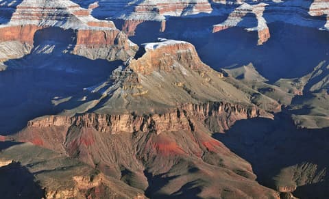 Snow-dusted Cheops Pyramid butte rises from the Grand Canyon's inner canyon in winter light.