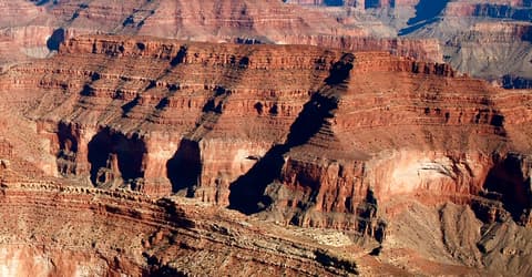 Aerial view of Horus Temple rising from layered red sandstone cliffs deep inside Grand Canyon National Park.