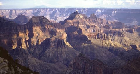 Sweeping panoramic view from Bright Angel Point on the Grand Canyon's North Rim at golden hour.