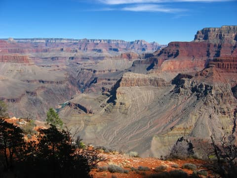 A sweeping Grand Canyon panorama from the Boucher Trail reveals layered red rock buttes and the Colorado River far below.