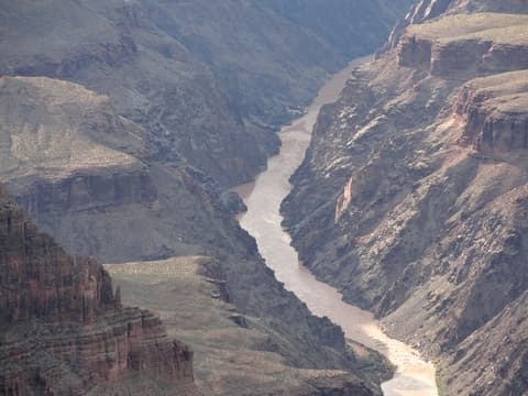 The muddy Colorado River winds through the steep inner gorge of Grand Canyon National Park.