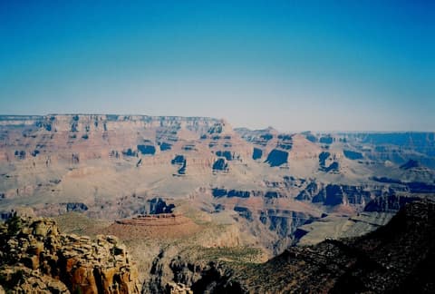 A sweeping panoramic view of Horseshoe Mesa and layered canyon walls under a clear blue Arizona sky.