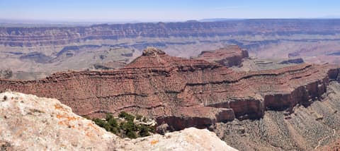 A sweeping panoramic view of Jupiter Temple and layered red rock formations from Cape Final on the North Rim.
