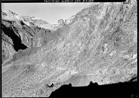A vintage black and white photograph of the historic Clear Creek Trail winding through Grand Canyon's rugged inner gorge.