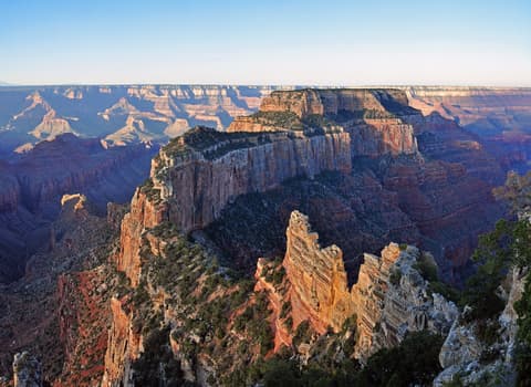 Layered red rock buttes and canyon walls glow in soft morning light at Cape Royal on the North Rim.