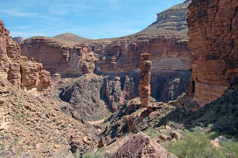 A lone sandstone rock spire stands dramatically along the Tonto Trail deep inside Grand Canyon National Park.